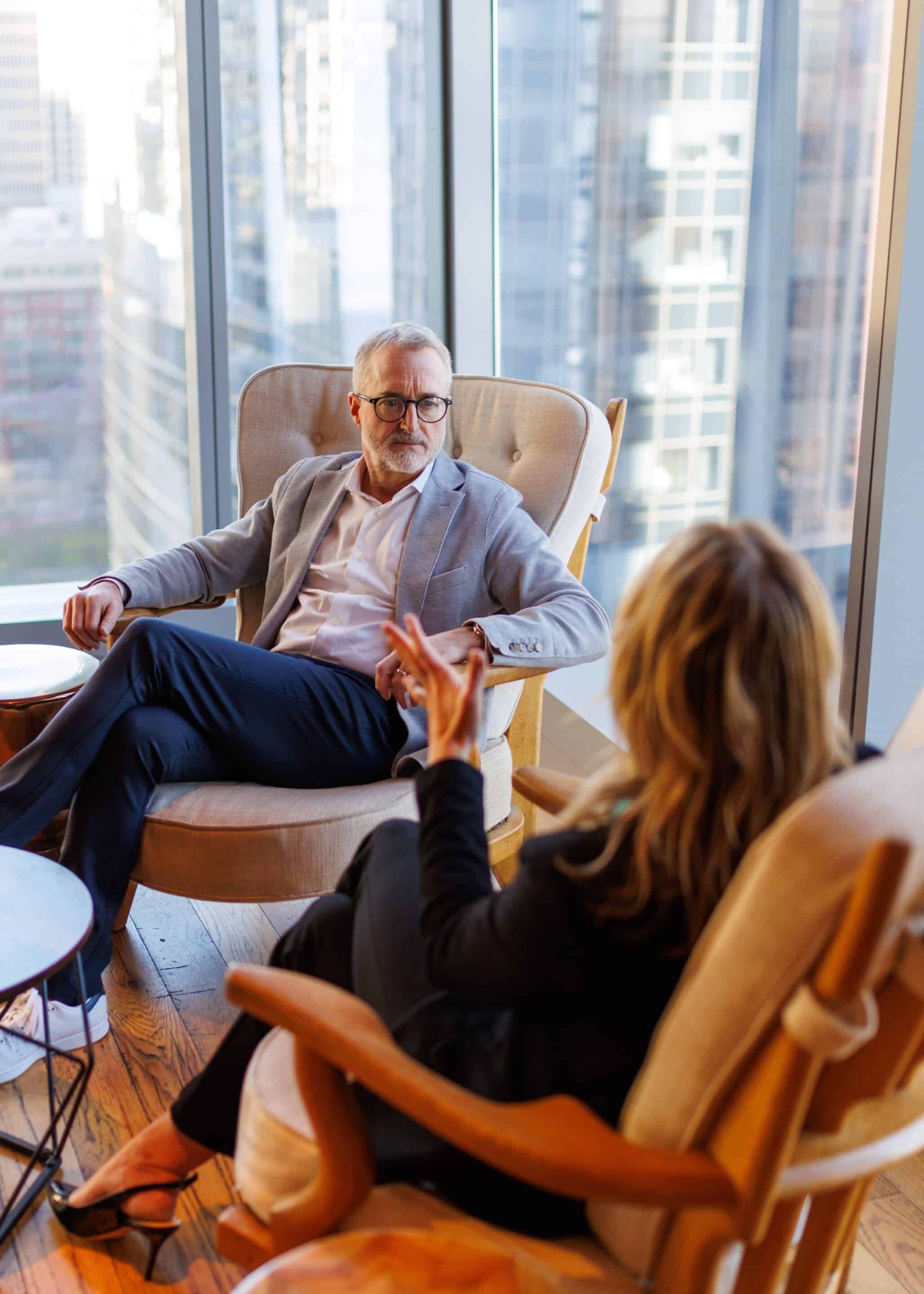 Two business people sitting in two chairs